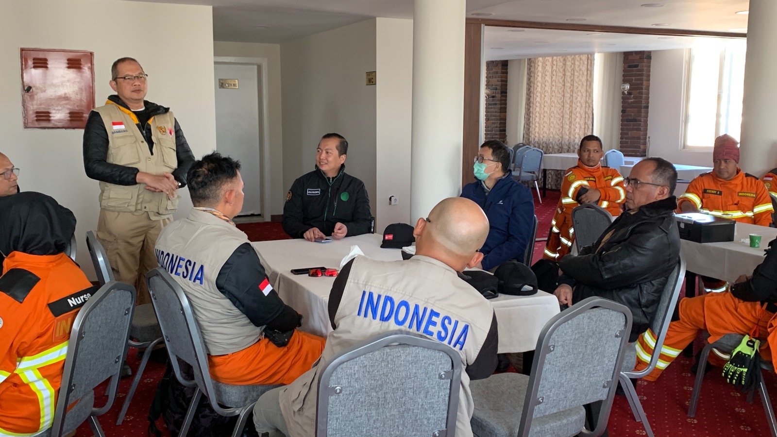 Para personel USAR Basarnas dan tim BNPB yang tergabung dalam Tim Kemanusiaan Indonesia mendengarkan arahan dari Dubes RI untuk Turkiye terkait dengan informasi terkini sebelum penerjunan Tim USAR menuju Hatay. 
